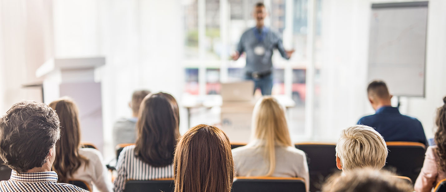 Rear view of business people attending a seminar in board room.